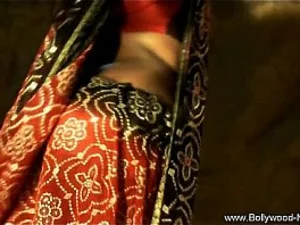 Seorang penari India yang menggoda melakukan tarian bayangan sensual, berjubah dalam kegelapan.
