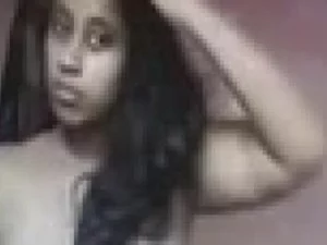 Une jeune femme tamoule aux gros seins se déshabille et pose de manière séduisante.