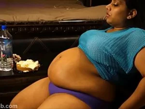 امرأة هندية ممتلئة الجسم تستمتع بتناول حلوى الجبن
